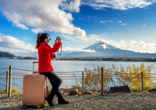 Woman take a photo at Fuji mountains. Autumn in Japan. Travel co